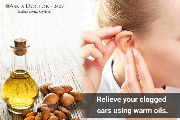  woman holding ear  with almond oil kept in side=